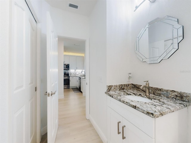 bathroom featuring vanity and wood-type flooring