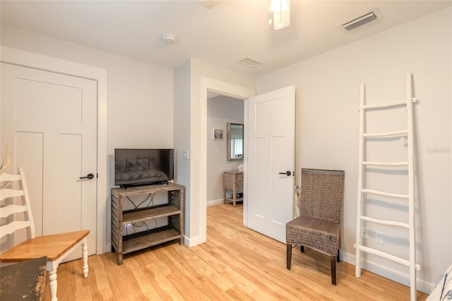 living area with ceiling fan and light hardwood / wood-style floors