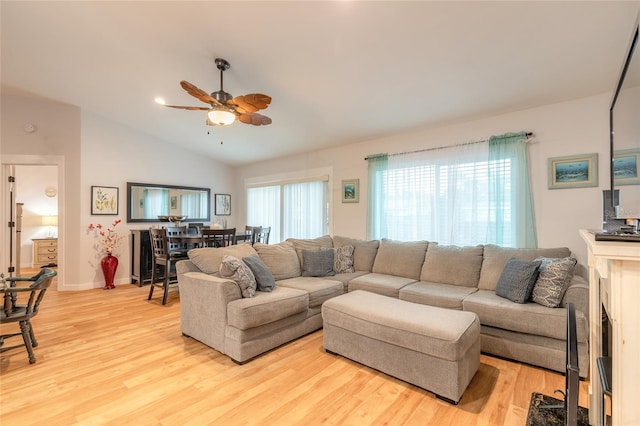 living room featuring vaulted ceiling, light hardwood / wood-style floors, and ceiling fan