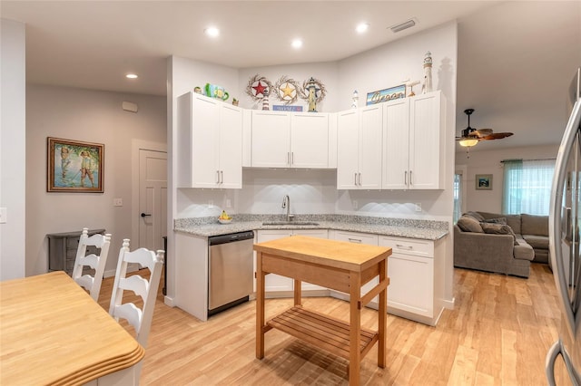 kitchen with white cabinetry, sink, ceiling fan, stainless steel appliances, and light hardwood / wood-style flooring