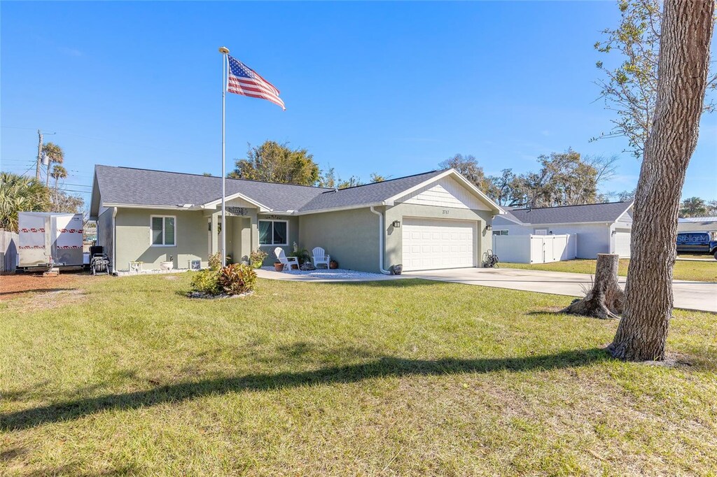 single story home featuring a garage and a front yard