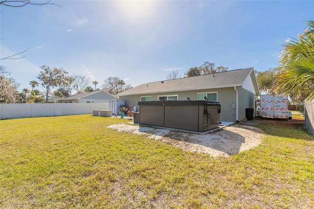 back of property featuring a jacuzzi and a lawn