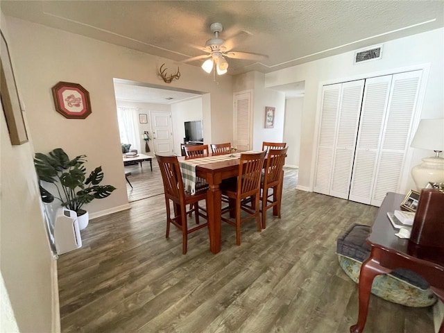 dining room with ceiling fan, a textured ceiling, and dark hardwood / wood-style flooring