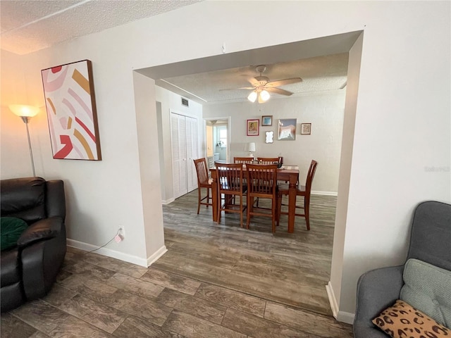 dining room featuring dark hardwood / wood-style flooring, a textured ceiling, and ceiling fan