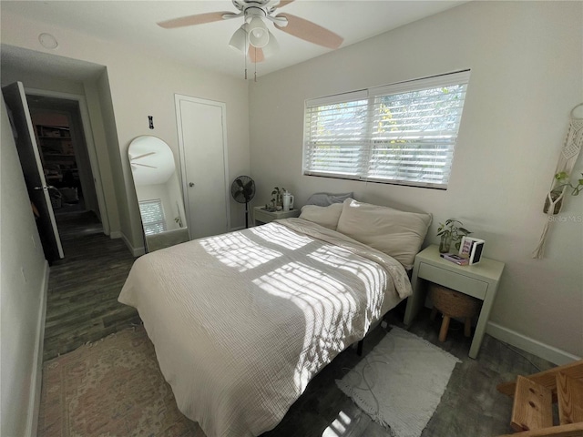 bedroom with dark hardwood / wood-style floors and ceiling fan