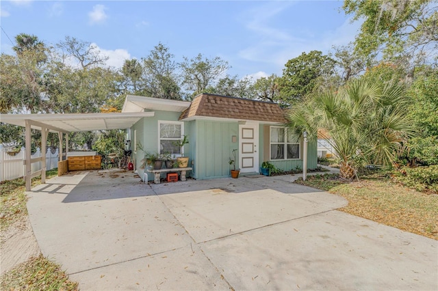 view of front of property with a carport and a hot tub