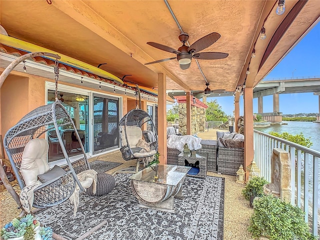 view of patio with a water view and ceiling fan