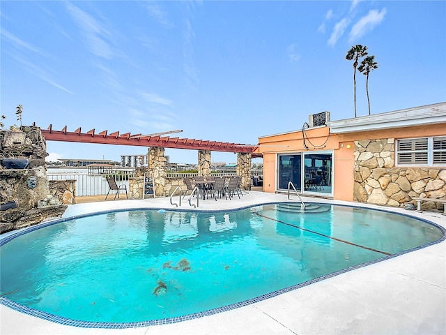 view of pool featuring a patio, a water view, and a pergola