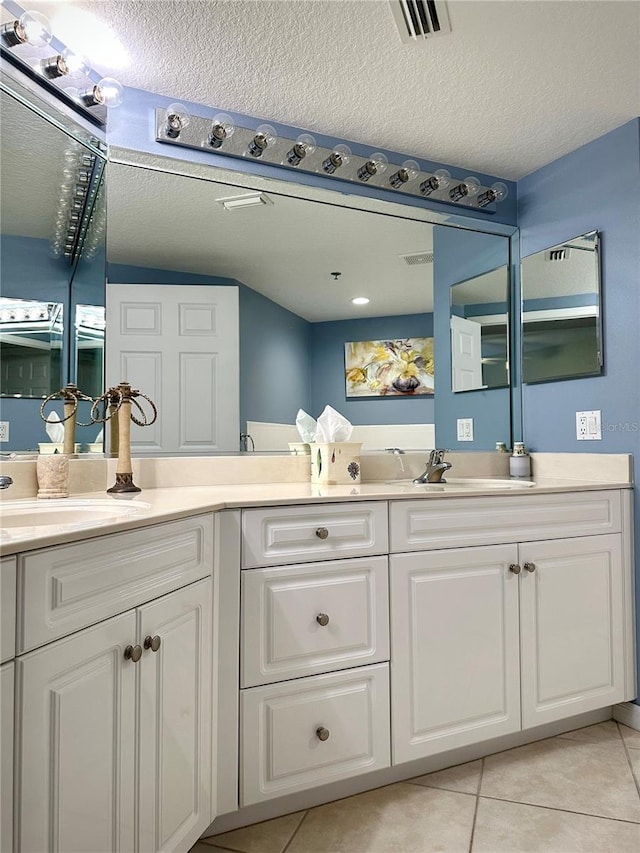 bathroom with vanity, tile patterned flooring, and a textured ceiling