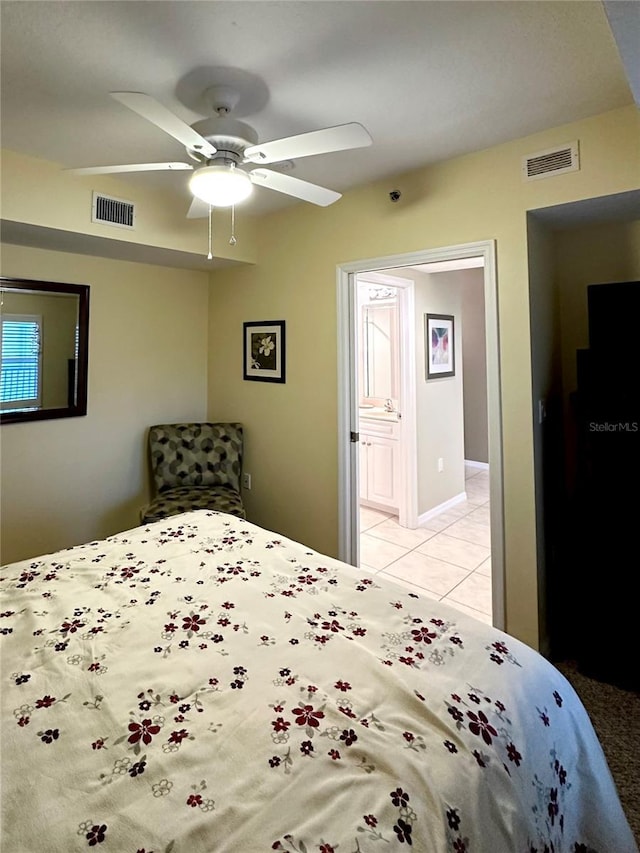 bedroom with light tile patterned floors, ensuite bath, and ceiling fan