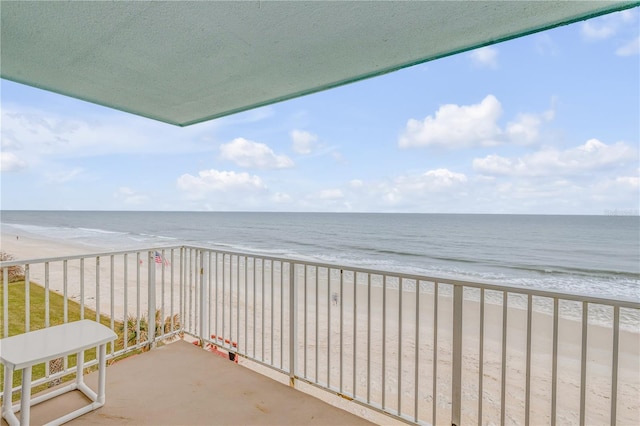 balcony featuring a water view and a beach view