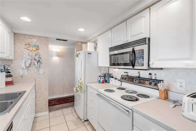 kitchen with white cabinetry, stainless steel appliances, sink, and light tile patterned floors