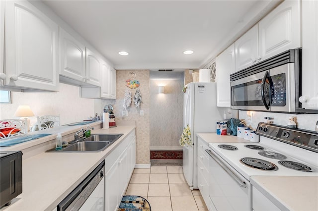 kitchen featuring white cabinetry, sink, light tile patterned flooring, and white appliances