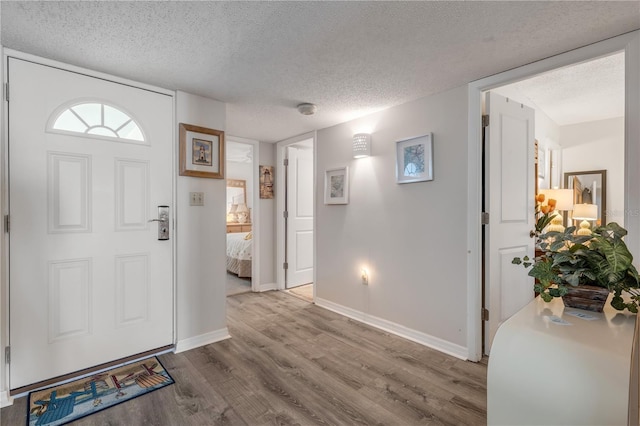 entrance foyer with light hardwood / wood-style floors and a textured ceiling