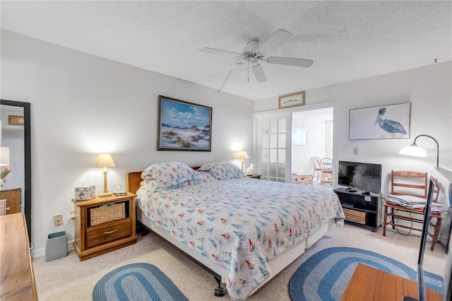 bedroom featuring ceiling fan, light colored carpet, and a textured ceiling