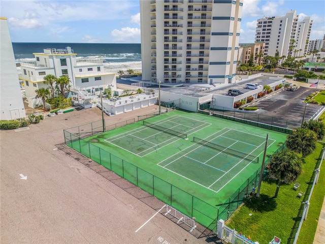 view of tennis court with a water view