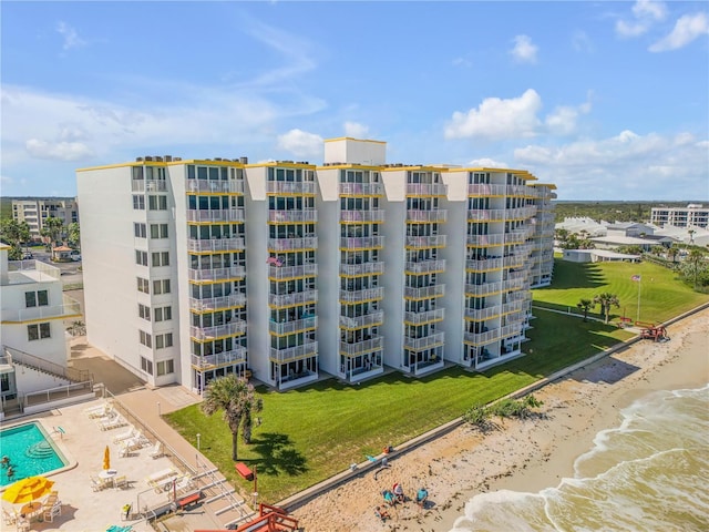 view of property with a water view and a beach view