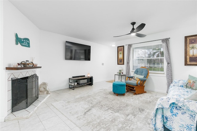 tiled living room featuring a fireplace and ceiling fan