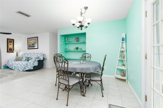 tiled dining room with built in features and a notable chandelier