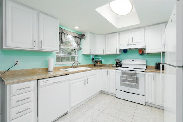 kitchen with white appliances, a skylight, sink, and white cabinets