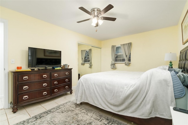 tiled bedroom featuring ceiling fan and a closet