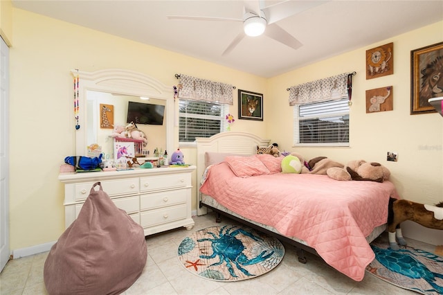 bedroom with multiple windows, light tile patterned floors, and ceiling fan