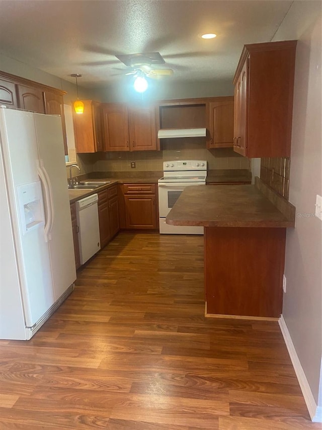 kitchen featuring sink, white appliances, hanging light fixtures, hardwood / wood-style flooring, and ceiling fan