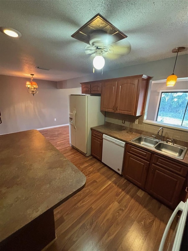 kitchen with dark hardwood / wood-style floors, decorative light fixtures, sink, ceiling fan, and white appliances