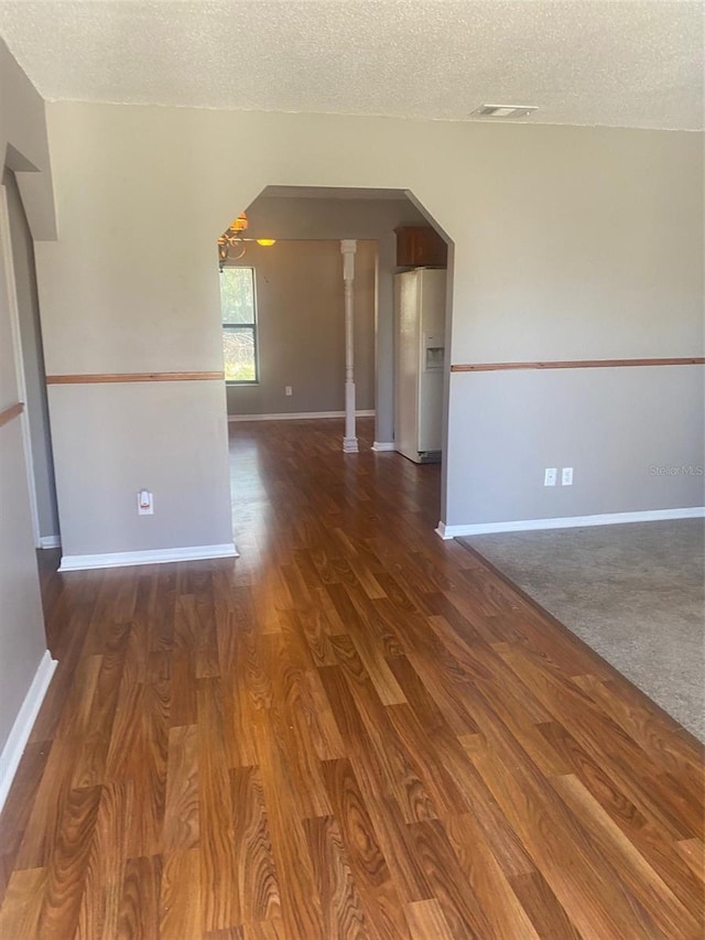 spare room with dark wood-type flooring and a textured ceiling