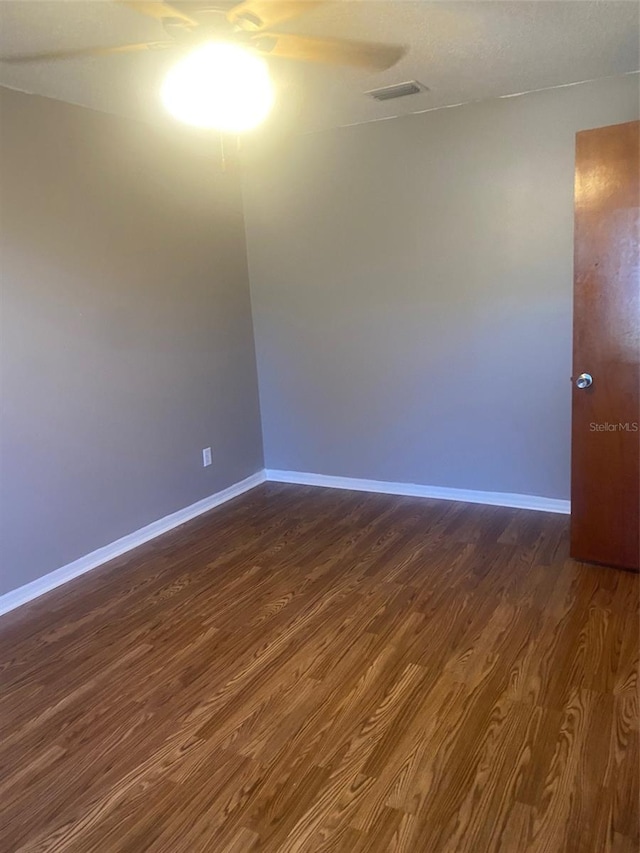 unfurnished room featuring ceiling fan and dark hardwood / wood-style flooring