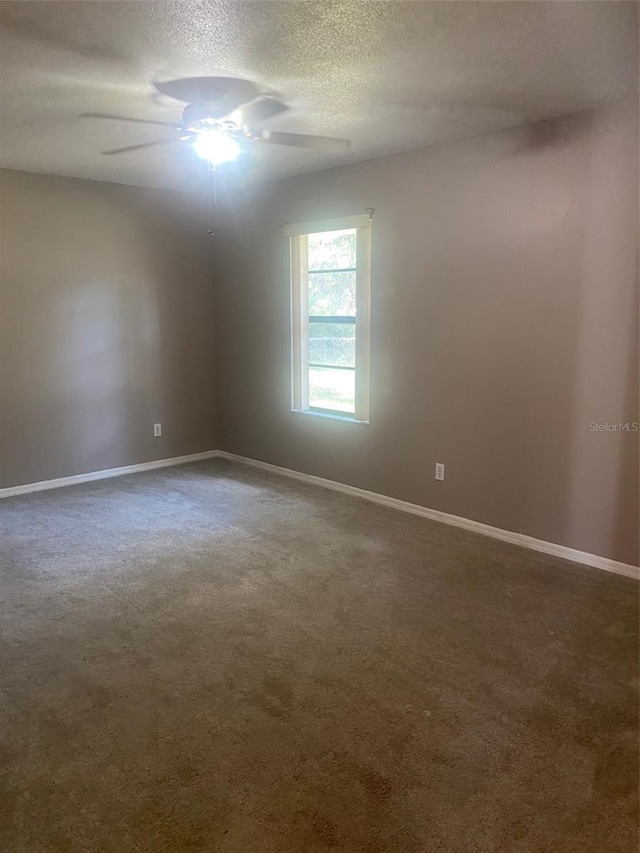 spare room featuring ceiling fan, carpet floors, and a textured ceiling