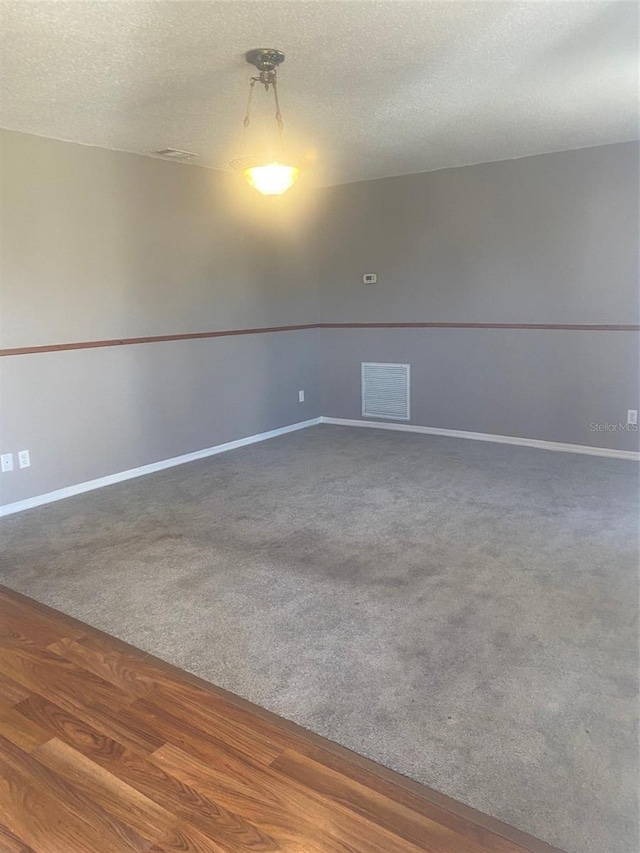 carpeted empty room with a textured ceiling