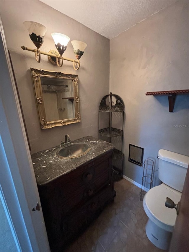 bathroom with vanity, tile patterned floors, a textured ceiling, and toilet