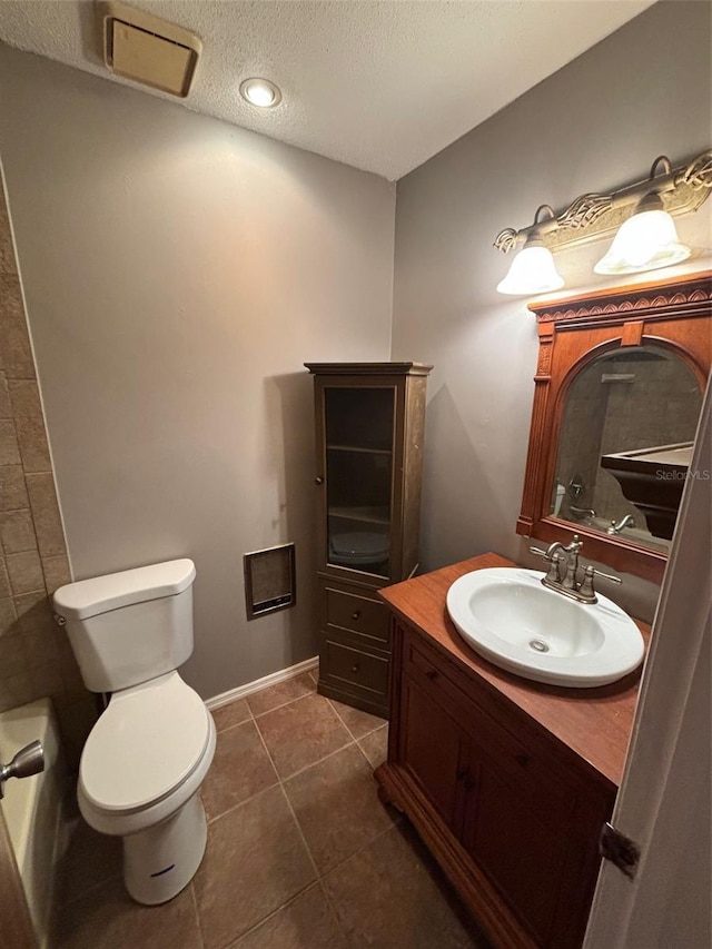 bathroom with tile patterned floors, toilet, a textured ceiling, and vanity