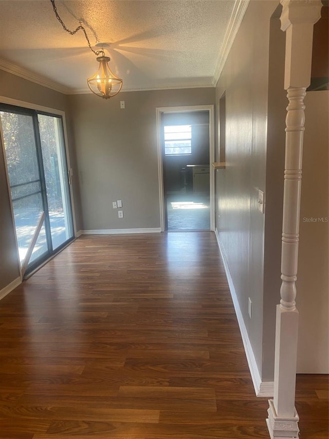 interior space featuring ornamental molding, dark hardwood / wood-style floors, and a textured ceiling