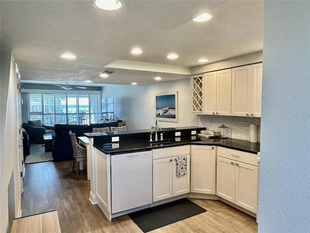 kitchen with white cabinets, light hardwood / wood-style flooring, kitchen peninsula, and dishwasher