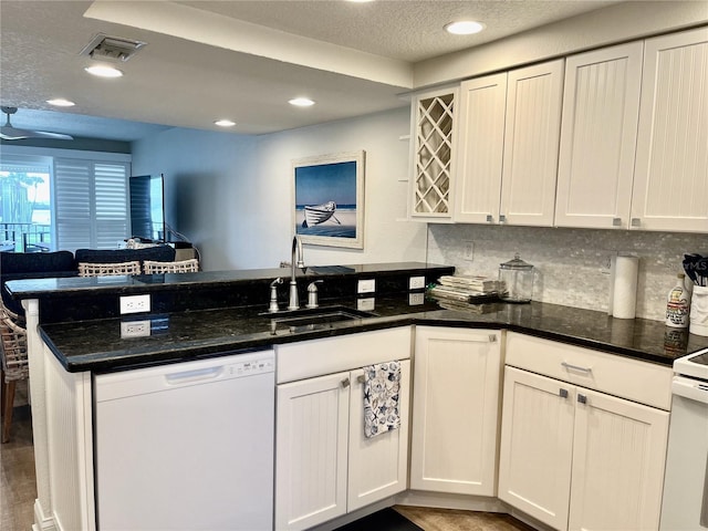 kitchen with sink, dark hardwood / wood-style flooring, dishwasher, kitchen peninsula, and white cabinets