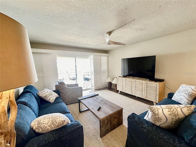 living room with ceiling fan and a textured ceiling