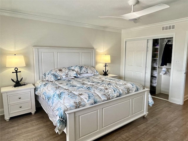 bedroom with crown molding, ceiling fan, dark hardwood / wood-style floors, and a closet