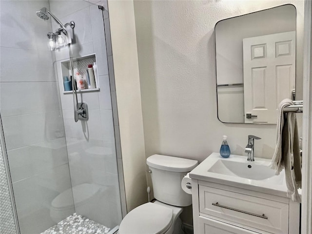 bathroom featuring vanity, walk in shower, and toilet