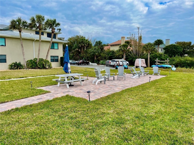 view of home's community featuring a lawn and a patio area