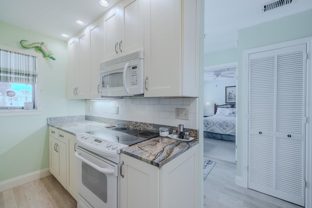 kitchen featuring light stone counters, white appliances, light hardwood / wood-style floors, and white cabinets