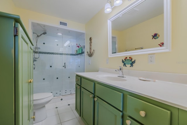 bathroom with vanity, a shower with shower door, tile patterned floors, and toilet