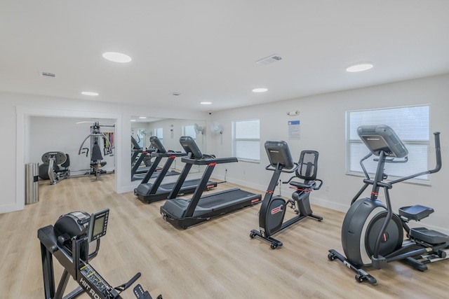 exercise room featuring radiator heating unit and light hardwood / wood-style flooring