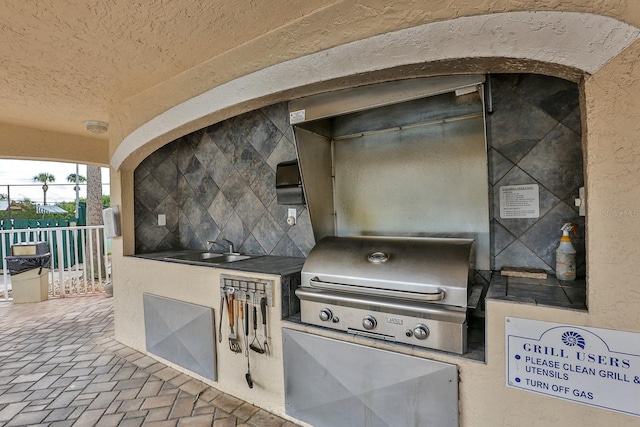 view of patio with area for grilling, a grill, and sink