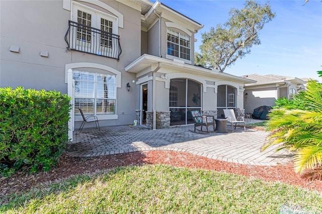 rear view of property featuring a sunroom and a patio