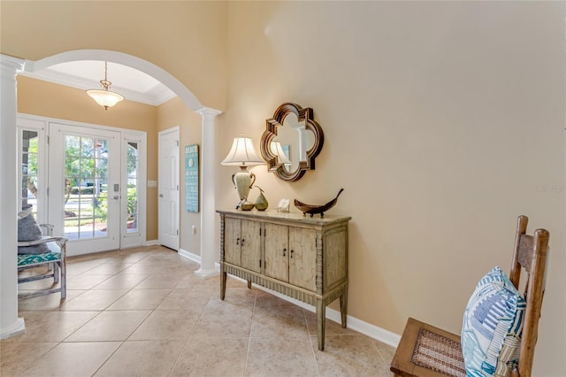 foyer entrance with ornamental molding, light tile patterned floors, and ornate columns