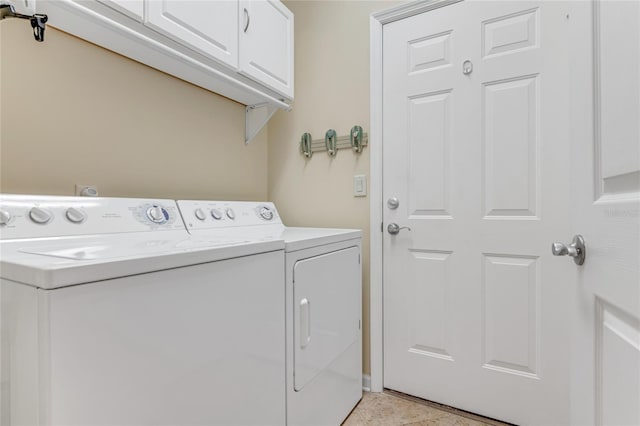 laundry room featuring cabinets, light tile patterned flooring, and washer and clothes dryer