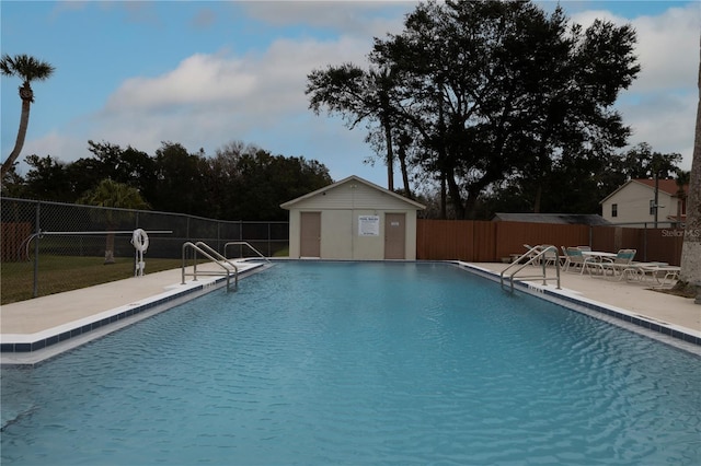 view of swimming pool with a patio and an outdoor structure