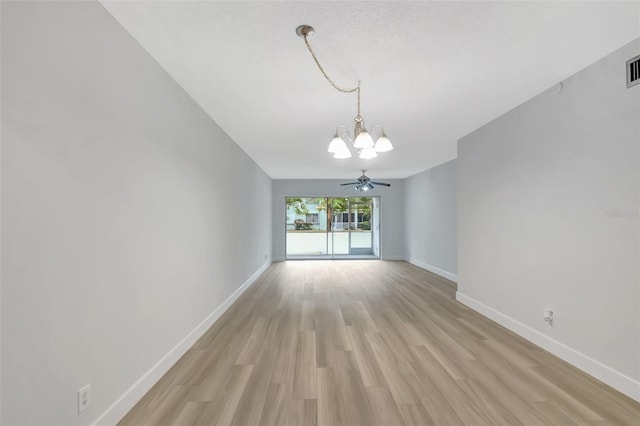 unfurnished dining area featuring ceiling fan with notable chandelier and light hardwood / wood-style floors